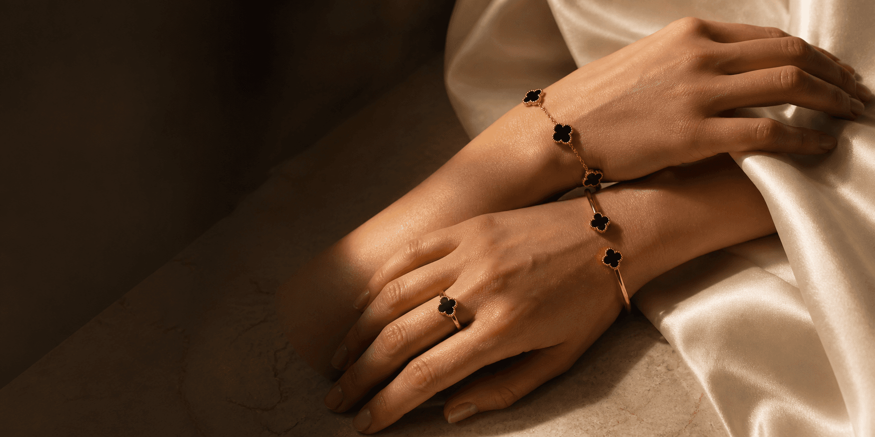 Hands wearing the black and gold Fleurette jewelry suite